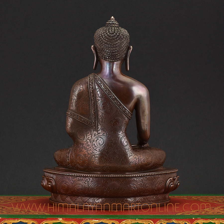 Back view of Shakyamuni Buddha Idol handcrafted in Nepal showing intricate carvings and patina finish.